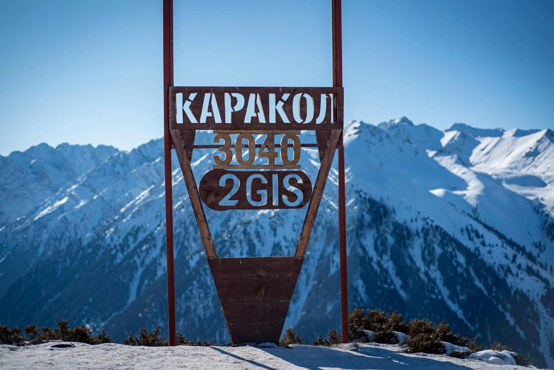 Табличка с надписью Каракол 3040 на горнолыжной базе в Кыргызстане