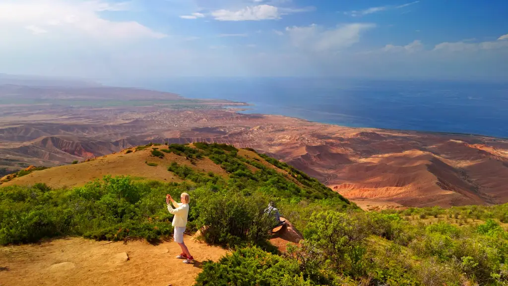 Туристы взобрались на зеленые горные хребты рядом с озером Иссык Куль